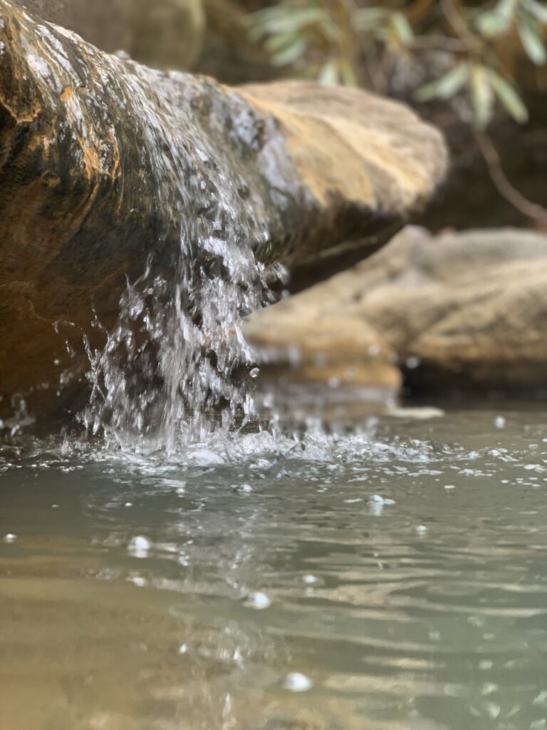 滝の様に岩上を流れ落ちる温泉