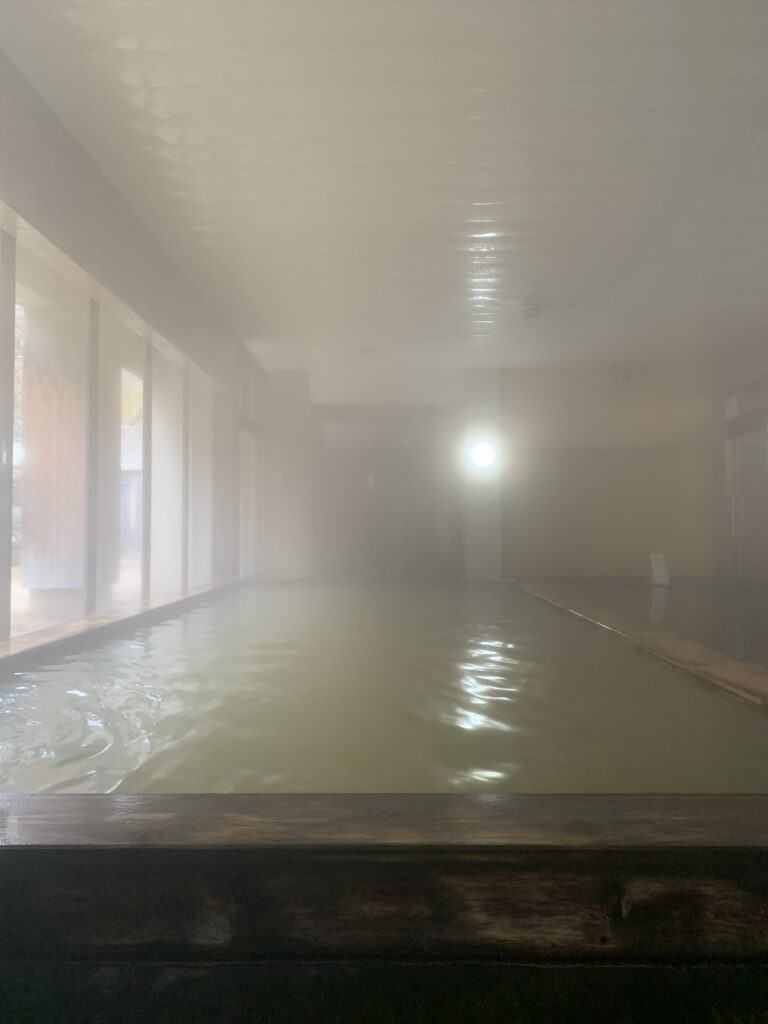 茶褐色の温泉が入った大きな檜風呂